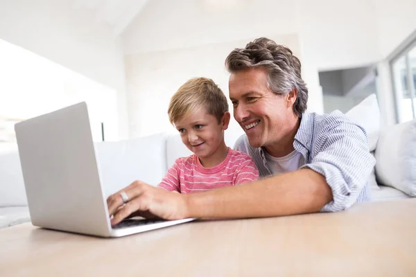 Baba ve oğul oturma odasında dizüstü bilgisayar kullanarak — Stok fotoğraf