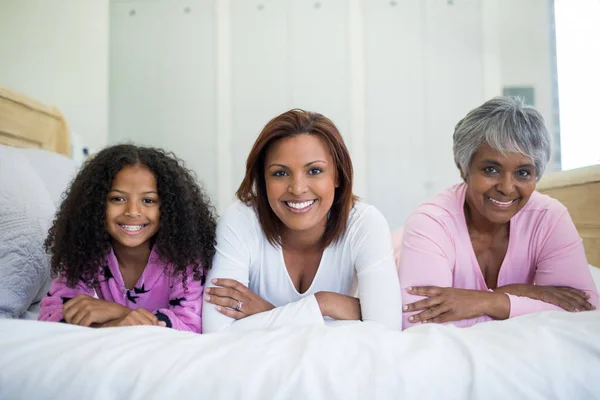 Happy family lying on bed in bed room — Stock Photo, Image