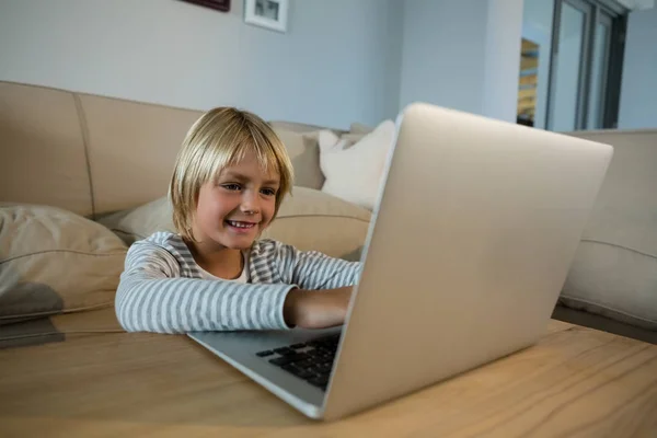 Menino usando laptop na sala de estar — Fotografia de Stock