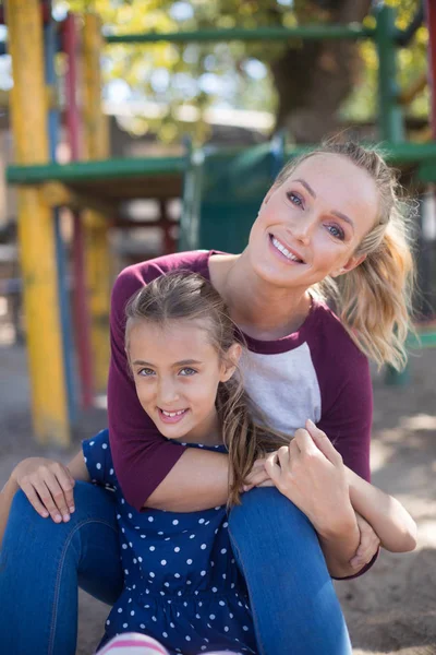 Moeder en dochter genietend van op speelplaats — Stockfoto