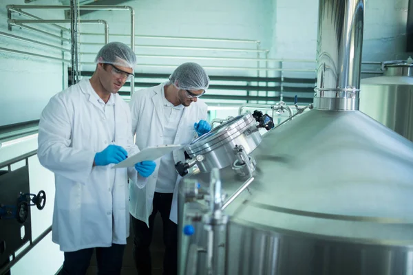 Scientists discussing at factory — Stock Photo, Image