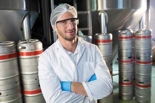 Worker standing by kegs at warehouse — Stock Photo, Image
