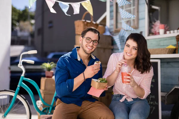 Couple sitting with snacks and juice — Stock Photo, Image