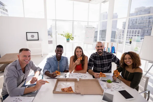 Leidinggevenden hebben pizza in vergaderruimte — Stockfoto