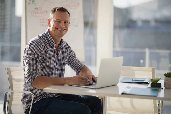 Confident executive using laptop at desk — Stock Photo, Image