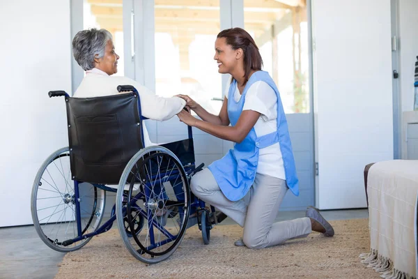 Medico che interagisce con la donna anziana sulla sedia a rotelle — Foto Stock