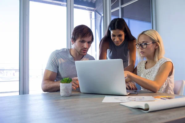 Chefer diskutera över laptop under mötet — Stockfoto