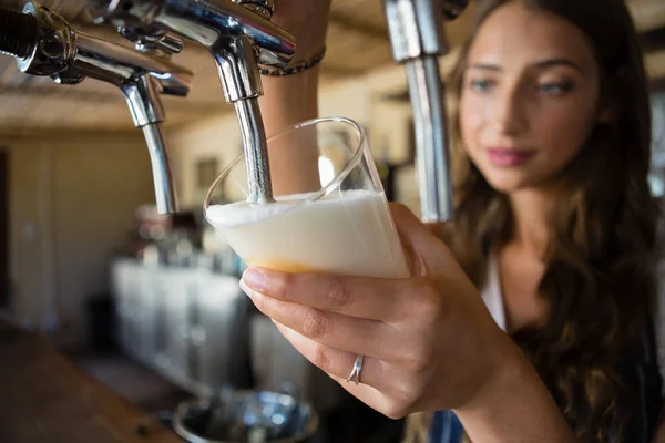 Camarera vertiendo cerveza de grifo en vidrio —  Fotos de Stock