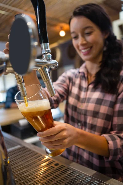 Krásná barmanka lejt pivo z kohoutku ve skle — Stock fotografie