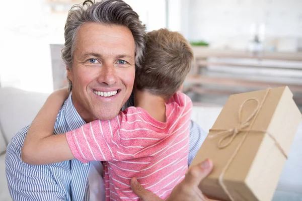 Vater umarmt Sohn bei Geschenkannahme — Stockfoto