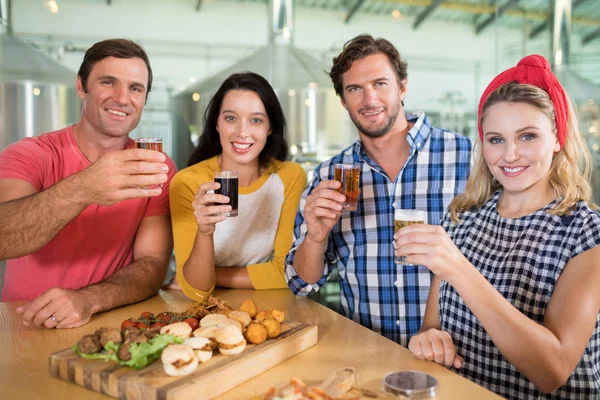 Amici che tengono bicchiere di birra nel ristorante — Foto Stock