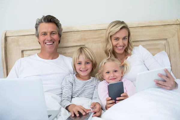 Famiglia utilizzando tablet, telefono e laptop digitali — Foto Stock