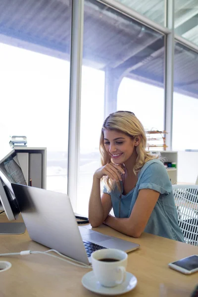 Executivo feminino usando laptop na mesa — Fotografia de Stock