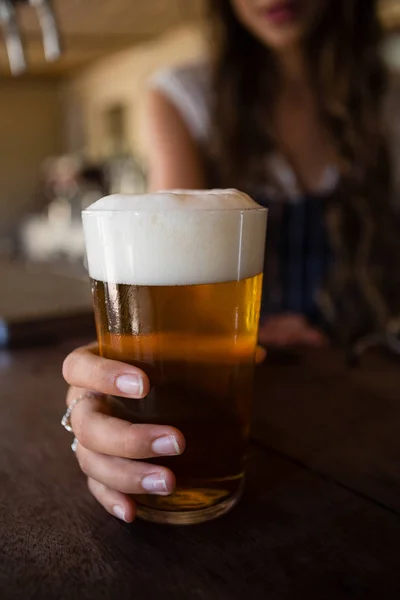 Gros plan de la serveuse tenant du verre à bière — Photo
