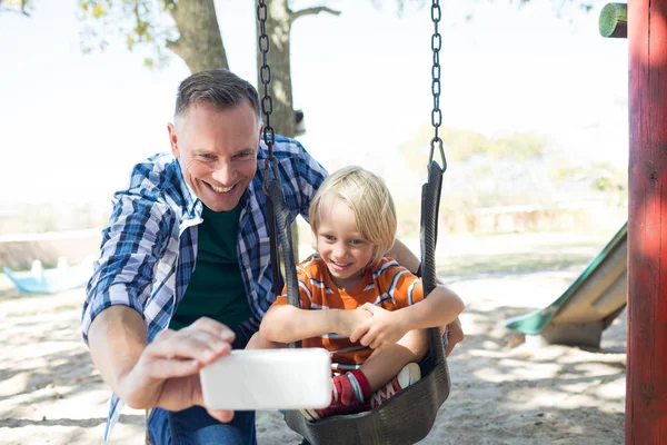 Vater macht Selfie mit Sohn auf Schaukel — Stockfoto