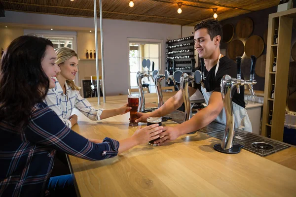 Barman que serve bebidas a amigas — Fotografia de Stock