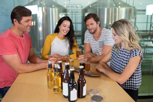 Friends enjoying beer at bar counter — Stock Photo, Image