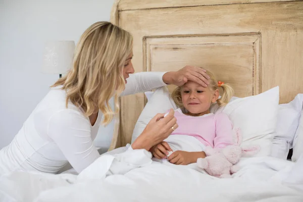Mãe verificando a temperatura doente filha — Fotografia de Stock