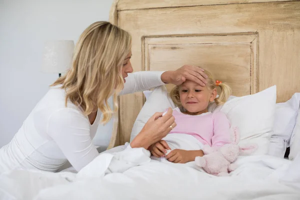 Mother checking sick daughter temperature — Stock Photo, Image