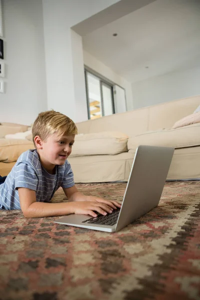 Junge benutzt Laptop im Wohnzimmer — Stockfoto