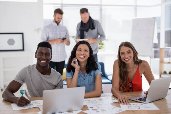 Giovani colleghi di lavoro che lavorano su laptop in ufficio — Foto Stock