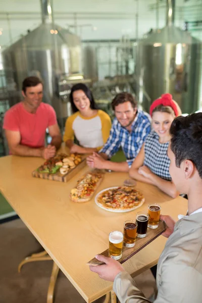 Barman serveert bierglas aan vrienden — Stockfoto