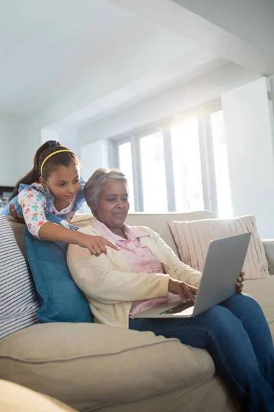 Grootmoeder en kleindochter met behulp van laptop — Stockfoto