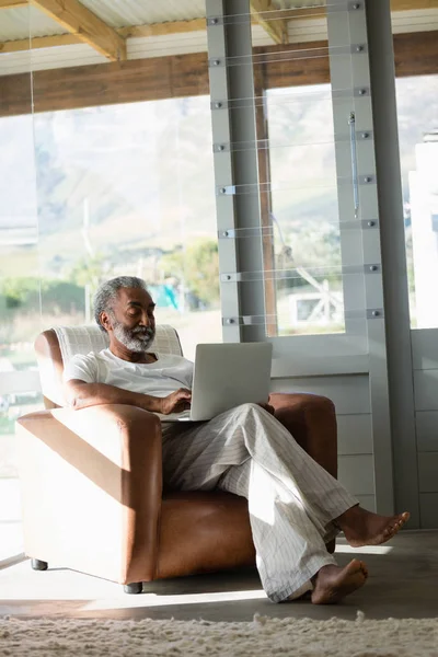 Homme âgé utilisant un ordinateur portable à la maison — Photo