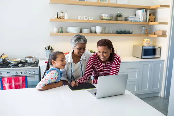 Famiglia utilizzando tablet grafico mentre guardando il computer portatile — Foto Stock