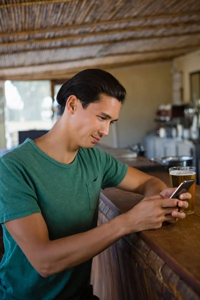 Człowiek przy użyciu telefonu w licznik bar — Zdjęcie stockowe