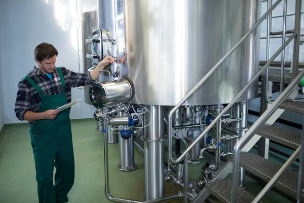 Male worker examining storage tank — Stock Photo, Image