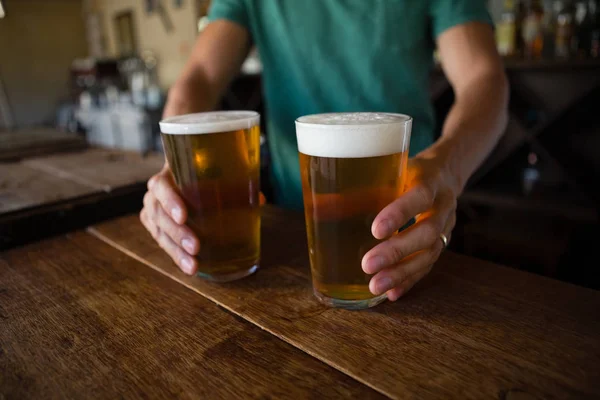 Midsection of bartender serving beer — Stock Photo, Image