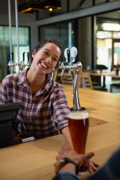 Happy barmanka podávající nápoj na člověka — Stock fotografie