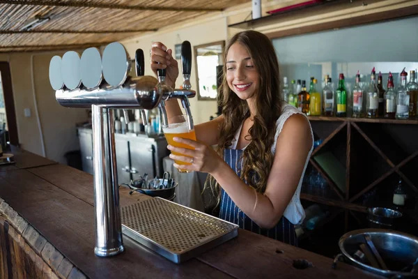 Camarera vertiendo cerveza de grifo en vidrio — Foto de Stock