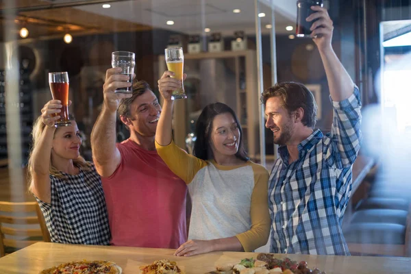 Vrolijke vrienden houden bier glas in bar — Stockfoto