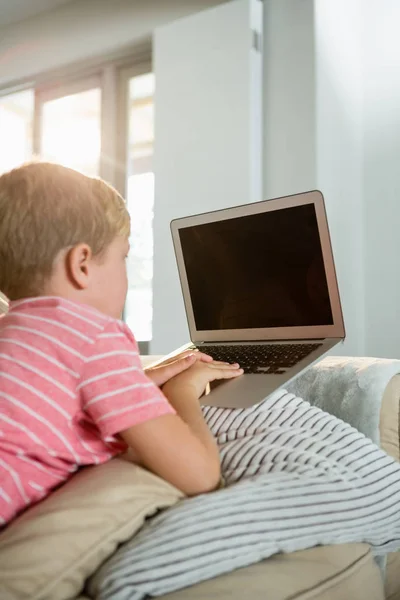 Junge benutzt Laptop im Wohnzimmer — Stockfoto