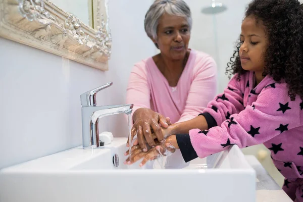 Grand-mère et petite-fille se lavent les mains — Photo