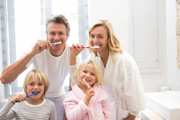 Família escovar os dentes juntos no banheiro — Fotografia de Stock