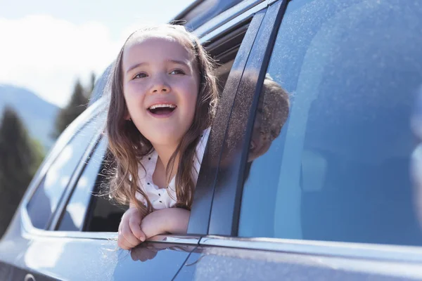 Menina bonito olhando para fora da janela do carro — Fotografia de Stock