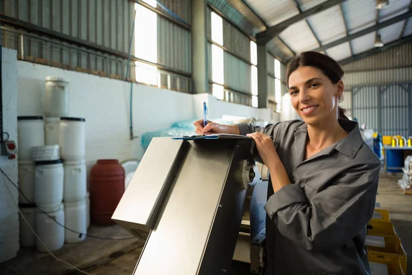 Trabajadora escribiendo en portapapeles — Foto de Stock