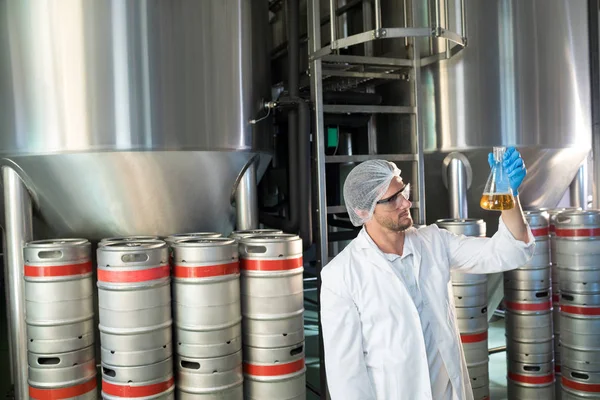 Tudós főzőpohárba sör vizsgálata — Stock Fotó