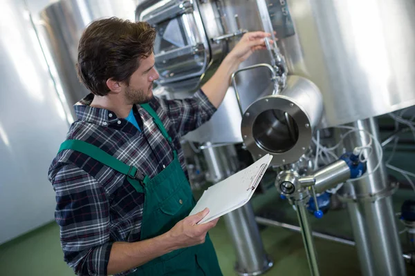 Trabajador examinando tanque de almacenamiento — Foto de Stock