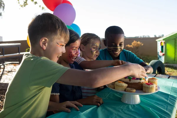 Enfants mangeant des aliments sucrés au parc — Photo