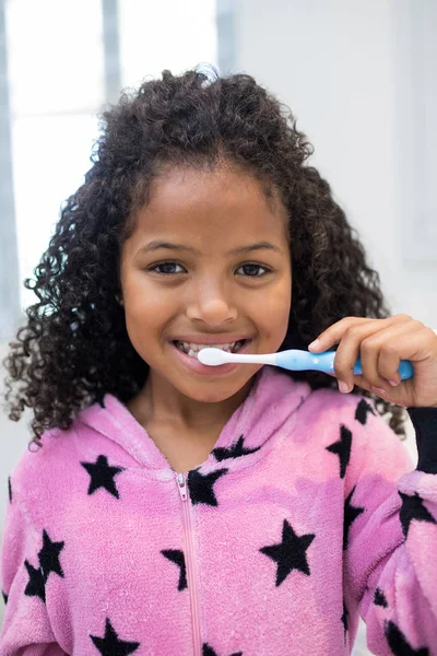 Sorridente ragazza lavarsi i denti in bagno — Foto Stock