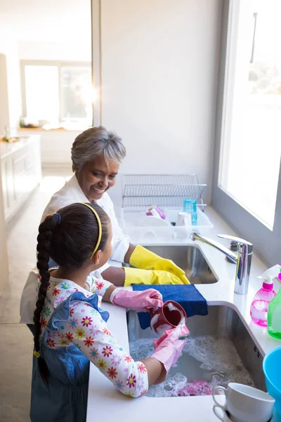 Бабушка и внучка стирают посуду — стоковое фото
