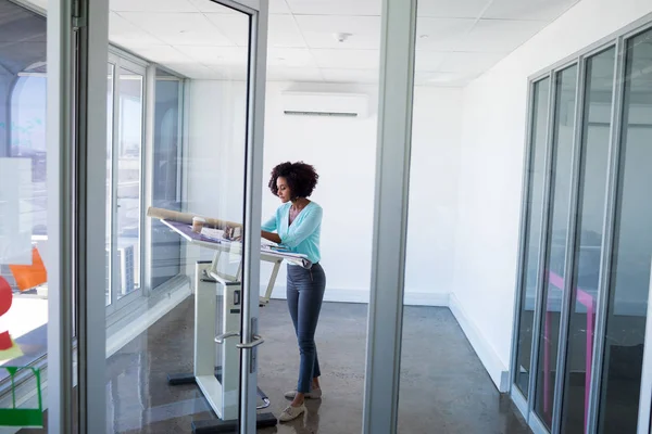 Female architect working on blueprint — Stock Photo, Image