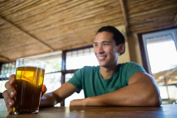 Homme avec verre de bière regardant loin — Photo