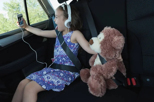 Menina tomando selfie com ursinho de pelúcia do telefone móvel — Fotografia de Stock