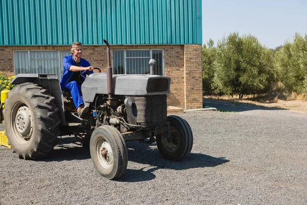 Aufmerksame Arbeiter am Steuer eines Traktors — Stockfoto
