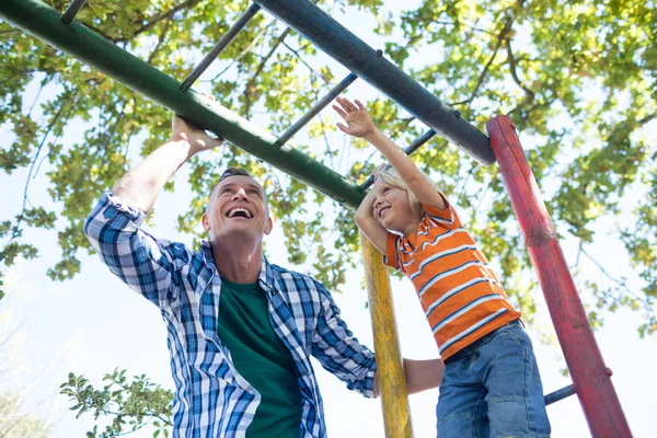 Father and son playing on jungle gym — Stock Photo, Image